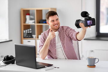 Image showing male blogger with camera videoblogging at home