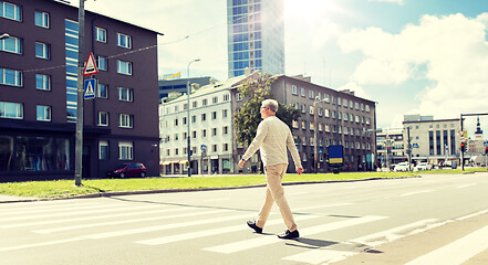 Image showing senior man walking along city crosswalk