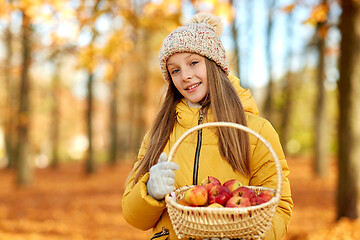 Image showing girl with apples in wicker basket at autumn park