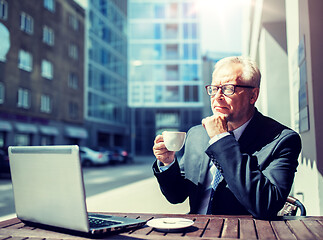 Image showing senior businessman with laptop drinking coffee