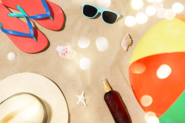 Image showing hat, flip flops and shades and beach ball on sand