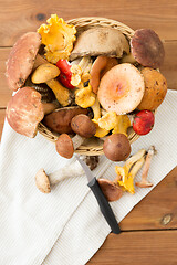 Image showing basket of different edible mushrooms and knife