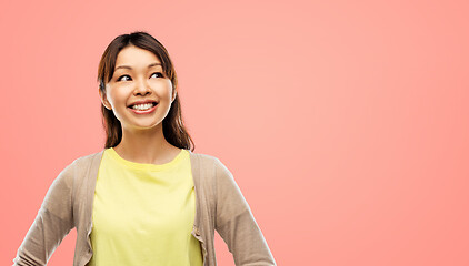 Image showing happy asian woman looking up over grey background