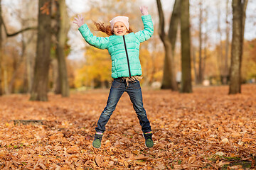 Image showing happy girl jumping and having fun at autumn park