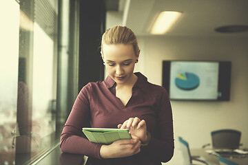 Image showing blonde businesswoman working on tablet at office