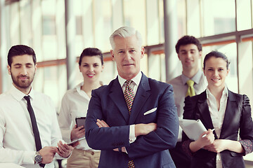 Image showing portrait of senior businessman as leader  with group of people i