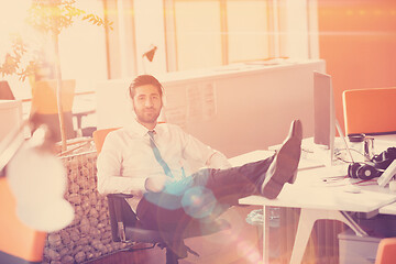 Image showing relaxed young businessman first at workplace at early morning