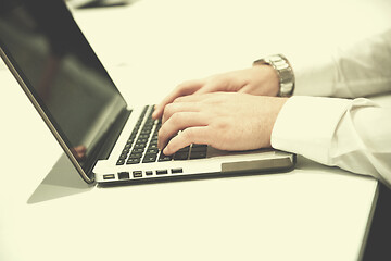 Image showing hands typing on laptop at meeting