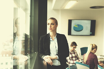 Image showing portrait of young business woman at office with team on meeting 