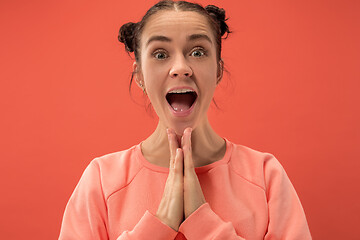 Image showing Beautiful woman looking suprised isolated on coral