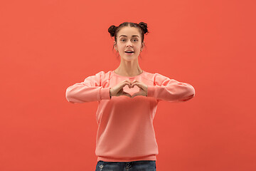 Image showing Portrait of attractive cute girl with bright makeup with love isolated over coral background