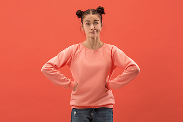 Image showing Beautiful woman looking suprised and bewildered isolated on coral