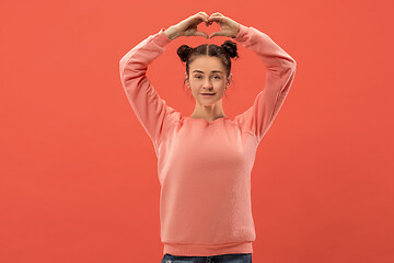 Image showing Portrait of attractive cute girl with bright makeup with love isolated over coral background