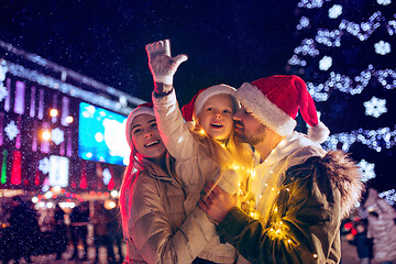 Image showing family, christmas, holidays, season and people concept - happy family over city background and snow