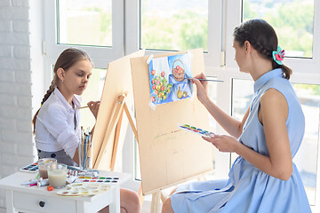 Image showing The family draws by the window, each has its own easel