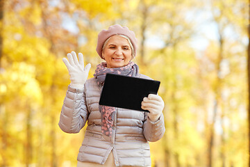 Image showing senior woman with tablet computer at autumn park