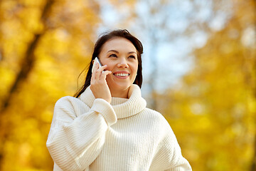 Image showing woman calling on smartphone in autumn park