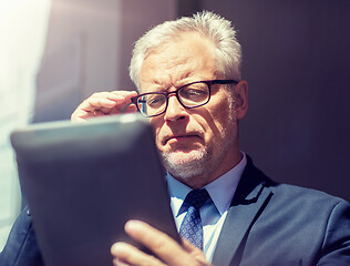 Image showing senior businessman with tablet pc on city street