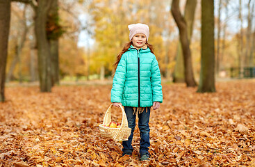 Image showing girl with apples in wicker basket at autumn park