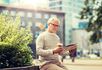 Image showing senior man reading newspaper and drinking coffee