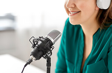 Image showing woman with microphone recording podcast at studio