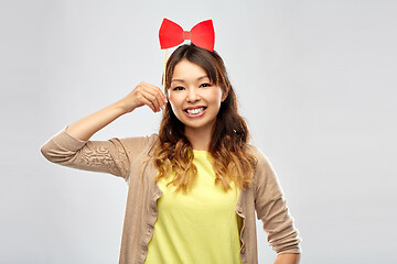 Image showing happy asian woman with big red bow