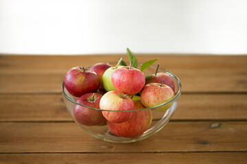 Image showing ripe apples in glass bowl on wooden table