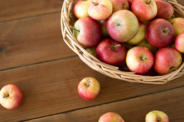 Image showing ripe apples in wicker basket on wooden table