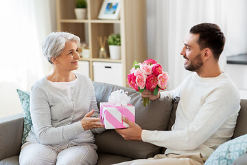 Image showing son giving present and flowers to senior mother