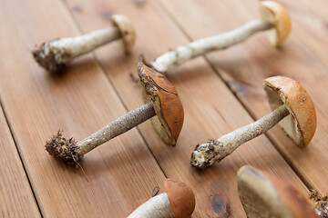 Image showing brown cap boletus mushrooms on wooden background