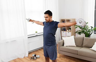 Image showing indian man exercising with dumbbells at home