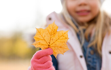 Image showing close up of little girl with maple leaf in autumn