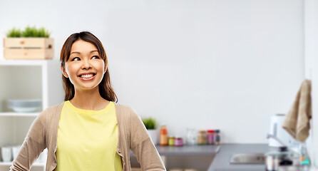 Image showing happy asian woman looking up at kitchen