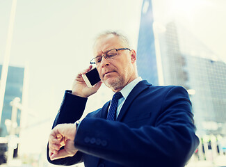 Image showing senior businessman calling on smartphone in city
