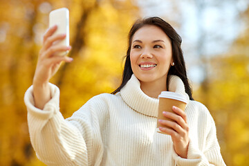 Image showing woman taking selfie by smartphone at autumn park