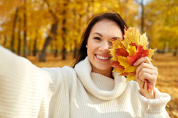 Image showing woman with leaves taking selfie in autumn park