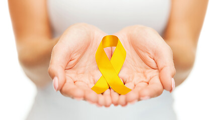 Image showing hands holding yellow gold cancer awareness ribbon