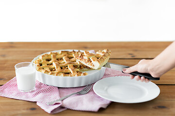 Image showing close up of hand with piece of apple pie on knife