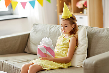 Image showing happy girl in party hat with birthday gift at home