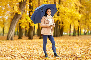 Image showing happy woman with umbrella in autumn park