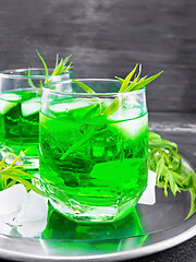 Image showing Lemonade Tarragon with ice in two glasses on dark board