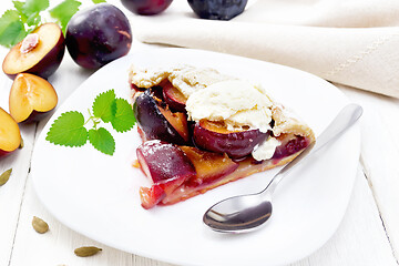 Image showing Galeta with plums in plate on wooden table