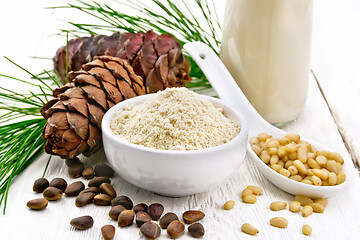 Image showing Flour cedar in bowl and nuts in spoon on wooden board