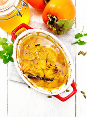 Image showing Persimmons baked with honey in pan on board top