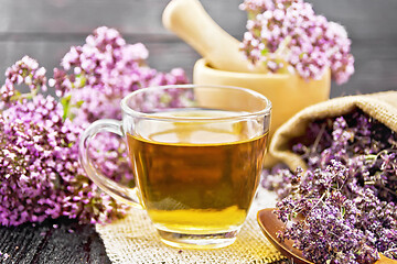 Image showing Tea of oregano in cup with mortar on table