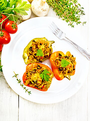 Image showing Pepper stuffed with mushrooms and couscous in plate on board top