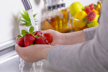 Image showing Woman washing strawberries in the kitchen