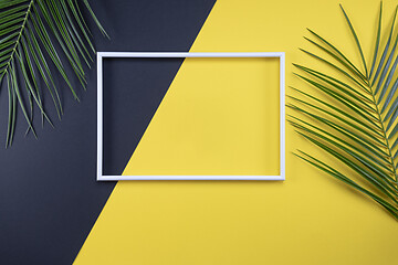 Image showing Summer composition with photo frame and green leaves on yellow b