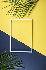 Image showing Summer composition with photo frame and green leaves on yellow b