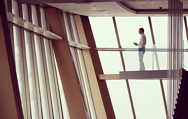 Image showing young successful business man in penthouse apartment working on 